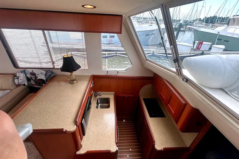 Slide: The Image of 2008 Mainship 34 Trawler interior with kitchen, countertop, and marina view. - 15