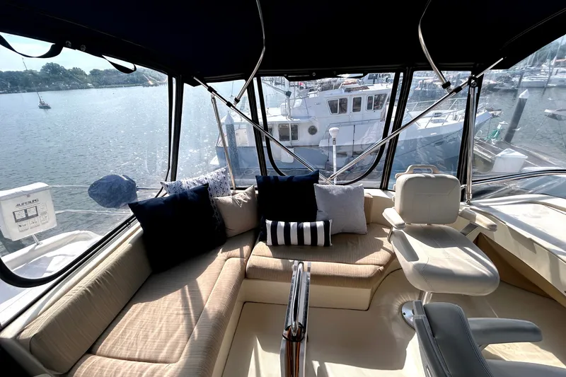 Slide: The Image of Interior view of 2008 Mainship 34 Trawler with comfortable seating and scenic marina backdrop. - 34