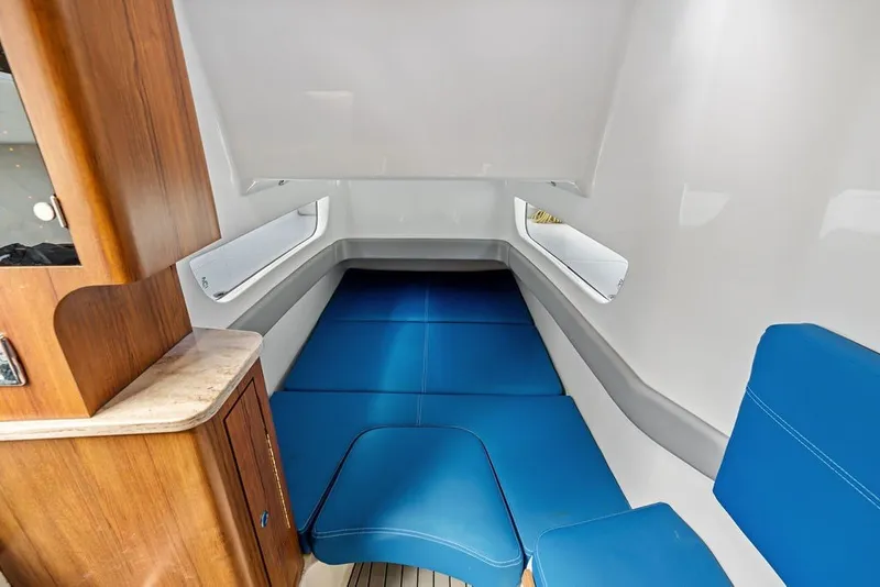 Slide: The Image of 2018 Invincible 42 Center Cabin interior with blue seating and wooden cabinetry. - 39