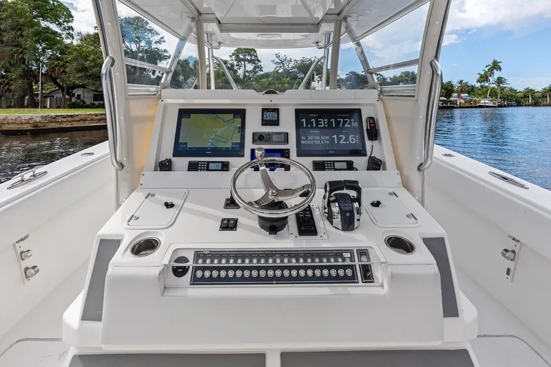 Slide: The Image of 2018 Invincible 42 Center Cabin boat dashboard with navigation screens and controls. - 22