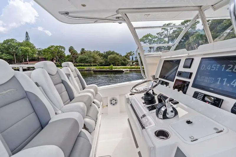 Slide: The Image of 2018 Invincible 42 Center Cabin boat interior with modern controls and seating. - 21