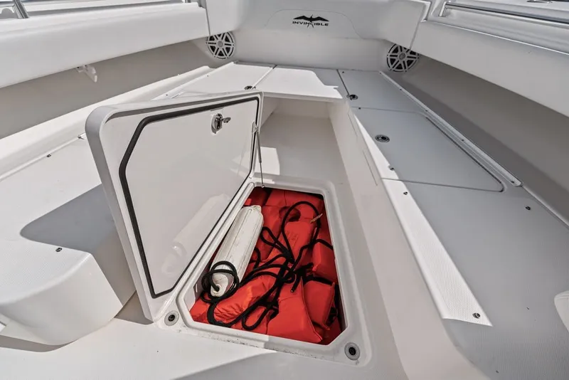 Slide: The Image of Open storage compartment on 2018 Invincible 42 Center Cabin boat with safety gear. - 35