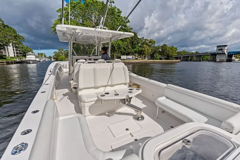 Slide: The Image of 2018 Invincible 42 Center Cabin boat cruising on a scenic river with lush greenery. - 17