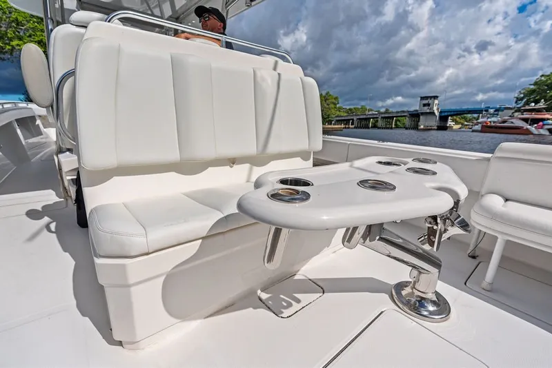 Slide: The Image of 2018 Invincible 42 Center Cabin boat interior with white seating and cup holders. - 18