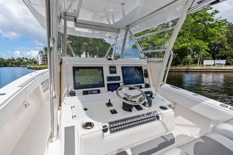Slide: The Image of Invincible 42 Center Cabin 2018 boat cockpit with navigation screens and steering wheel. - 23