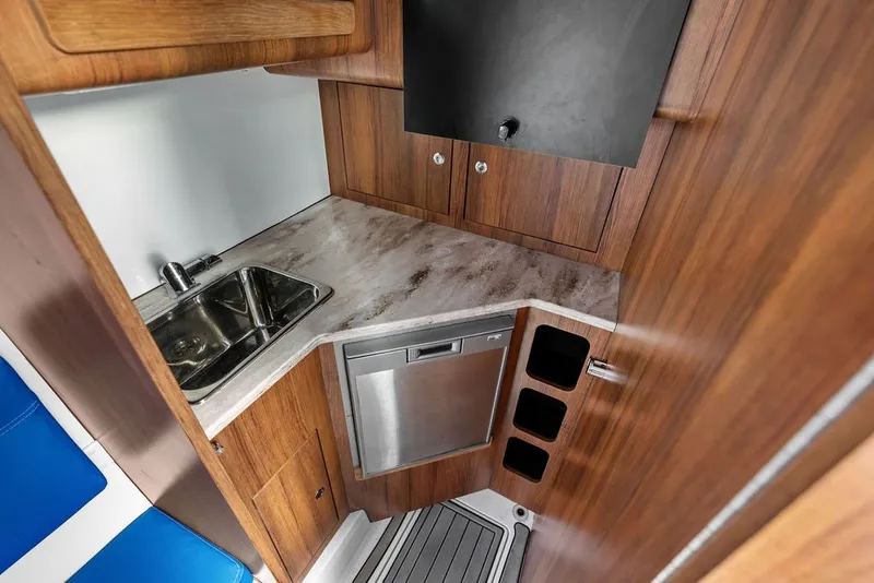Slide: The Image of 2018 Invincible 42 Center Cabin interior with wood finish, sink, and compact kitchen area. - 37