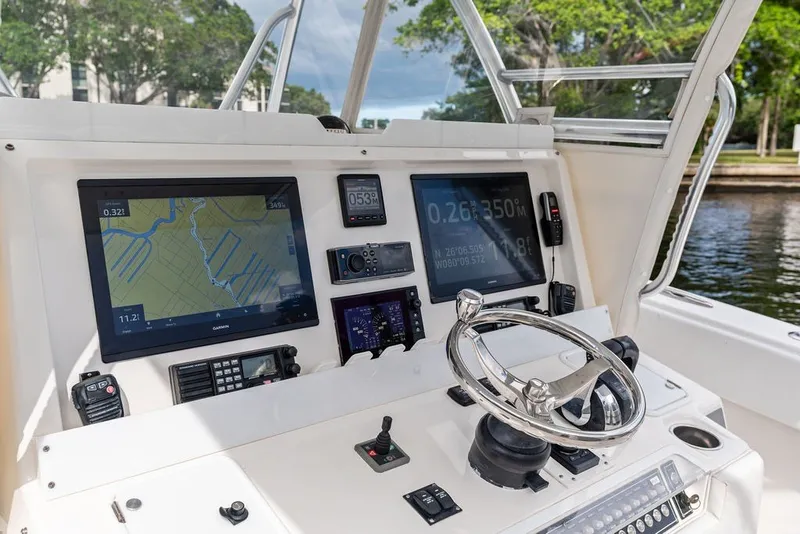 Slide: The Image of Cockpit of 2018 Invincible 42 Center Cabin with navigation screens and steering wheel. - 24