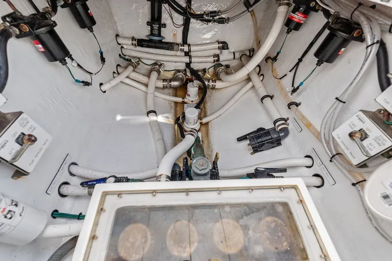 Slide: The Image of Engine room of 2018 Invincible 42 Center Cabin with visible pipes and filters. - 42