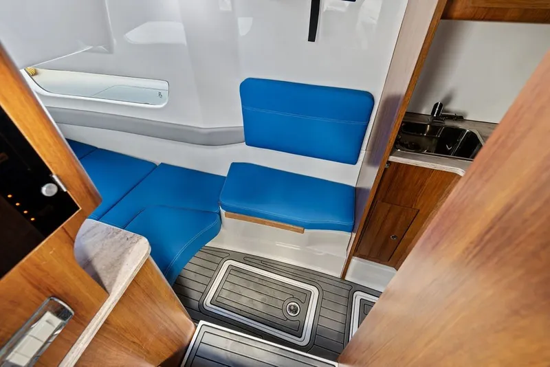 Slide: The Image of Interior of 2018 Invincible 42 Center Cabin with blue seating and compact kitchenette. - 36