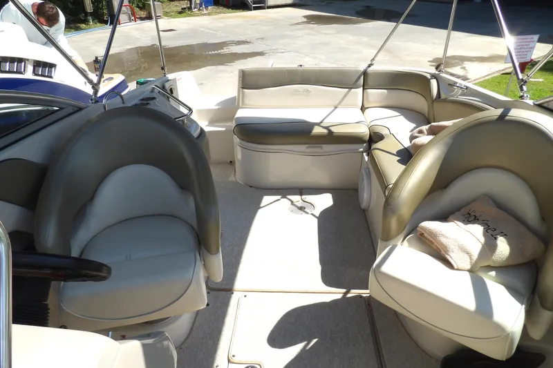 Slide: The Image of 2005 Sea Ray 240 Sundeck interior with beige seating and steering wheel. - 24