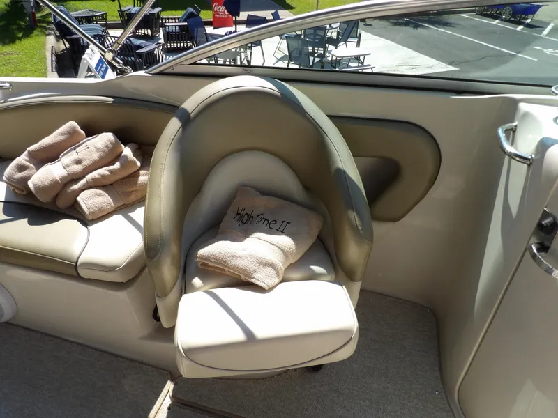 Slide: The Image of 2005 Sea Ray 240 Sundeck interior with beige seating and towels. - 15
