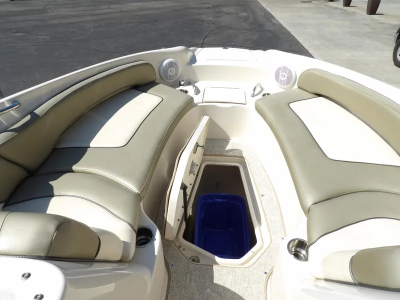 Slide: The Image of 2005 Sea Ray 240 Sundeck interior with beige seating and storage compartment. - 17