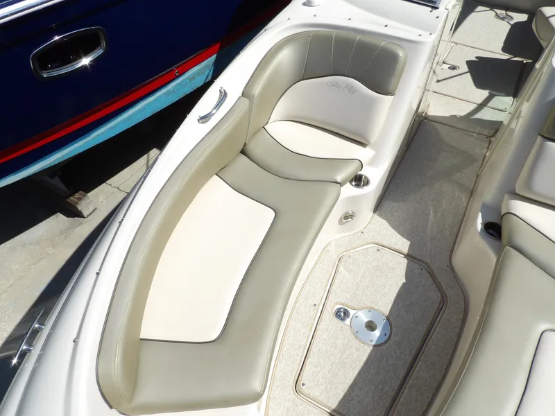 Slide: The Image of 2005 Sea Ray 240 Sundeck boat interior with beige seating and storage compartment. - 20
