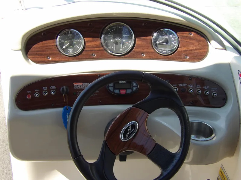 Slide: The Image of 2005 Sea Ray 240 Sundeck dashboard with wood accents and steering wheel. - 13