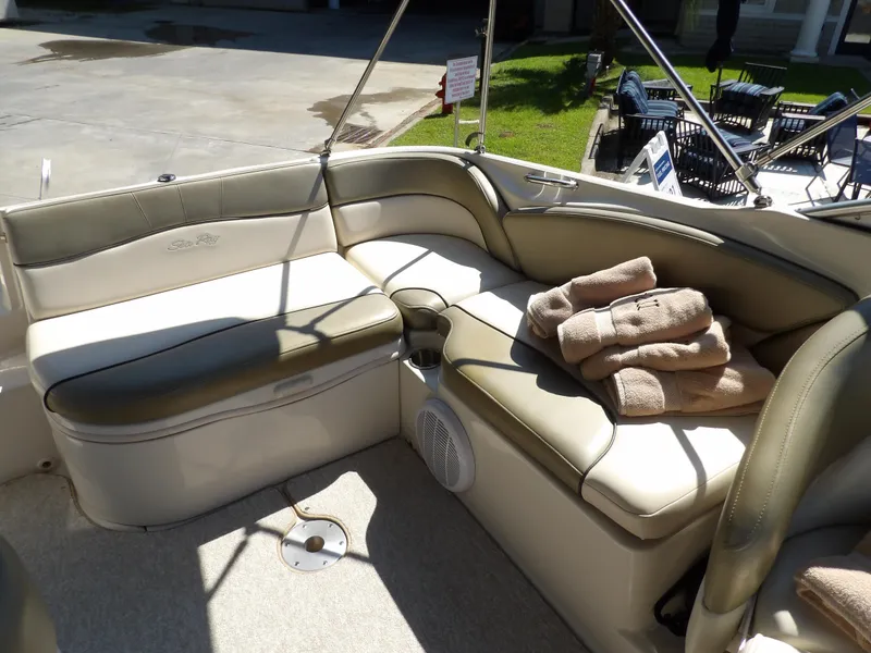 Slide: The Image of 2005 Sea Ray 240 Sundeck interior with beige seating and towels. - 26