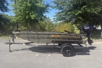 The Image of 2027 Tracker Grizzly 1553 Timber boat on trailer, parked outdoors. - 0