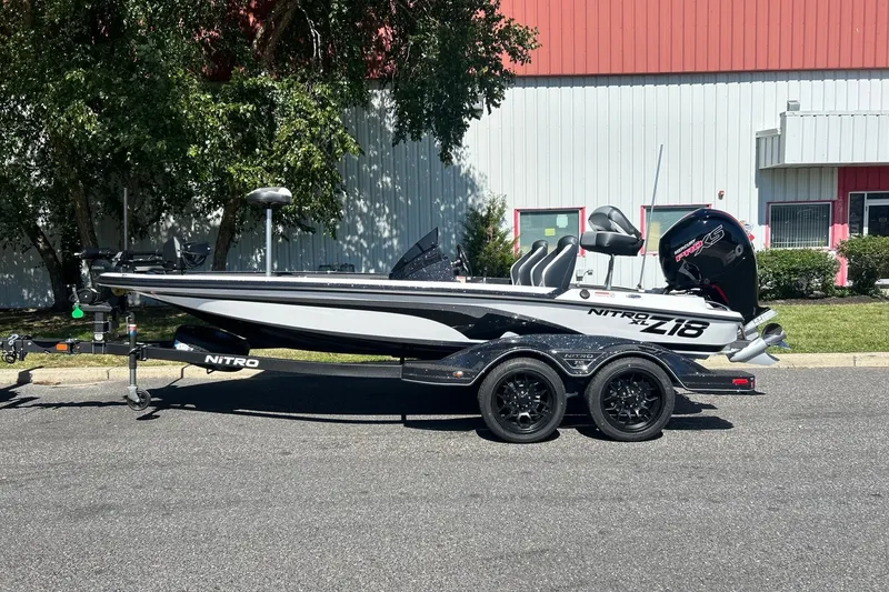 Slide: The Image of 2027 Nitro Z18 XL Pro boat on trailer, parked outdoors near industrial building. - 1