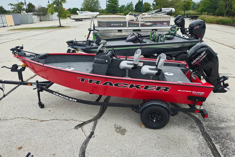 The Image of Red 2027 Tracker Super Guide V-16 SC boat on trailer, parked outdoors. - 1