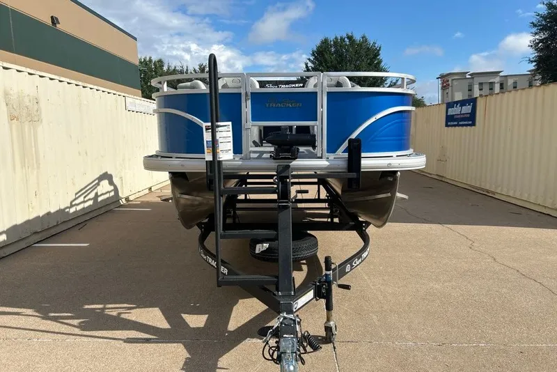 Slide: The Image of 2027 Sun Tracker Fishin' Barge 20 DLX pontoon boat on trailer, parked outdoors. - 16
