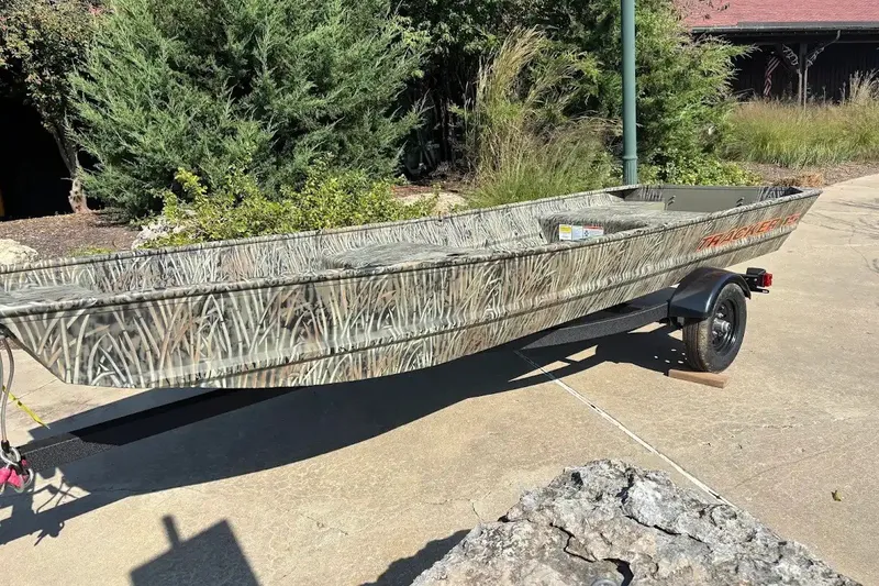The Image of 2027 Tracker Grizzly 15 Jon boat with camouflage design on a trailer. - 0