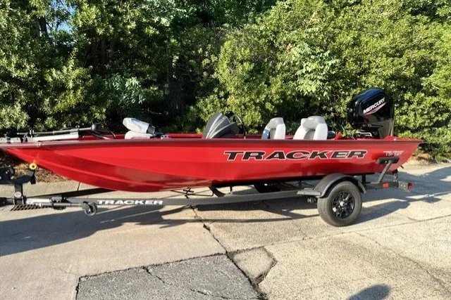 The Image of 2027 Tracker Pro Team 175 boat in red on trailer, parked outdoors. - 0