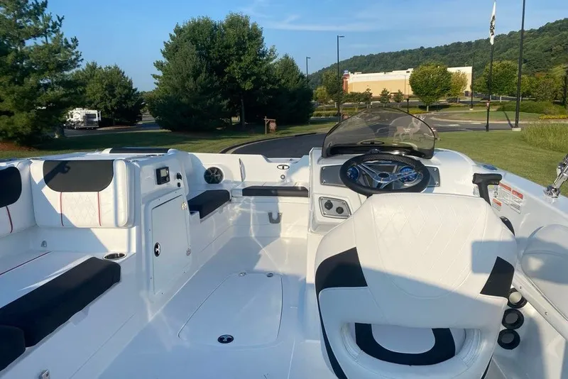 Slide: The Image of 2027 Tahoe 2150 boat interior with sleek seating and modern dashboard, set in a scenic outdoor location. - 5
