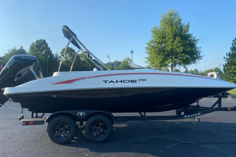 The Image of 2027 Tahoe 2150 boat on trailer, parked outdoors with trees in background. - 0
