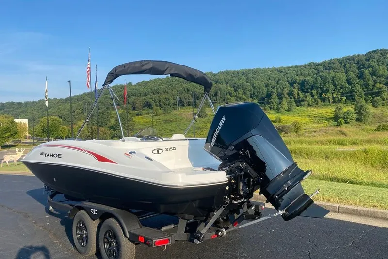 Slide: The Image of 2027 Tahoe 2150 boat with Mercury engine on trailer, scenic background. - 2