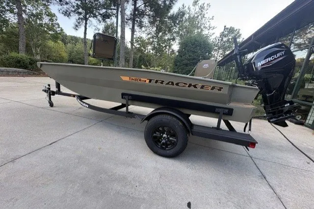 The Image of 2027 Tracker Grizzly 1553 Timber boat on trailer with Mercury engine, parked outdoors. - 0