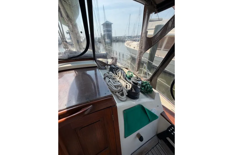 Slide: The Image of 1983 Tayana Aft Cockpit sailboat interior with ropes and winch, docked at marina. - 25