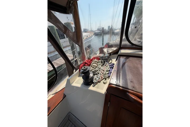 Slide: The Image of 1983 Tayana Aft Cockpit sailboat interior with ropes and winch, docked at marina. - 28