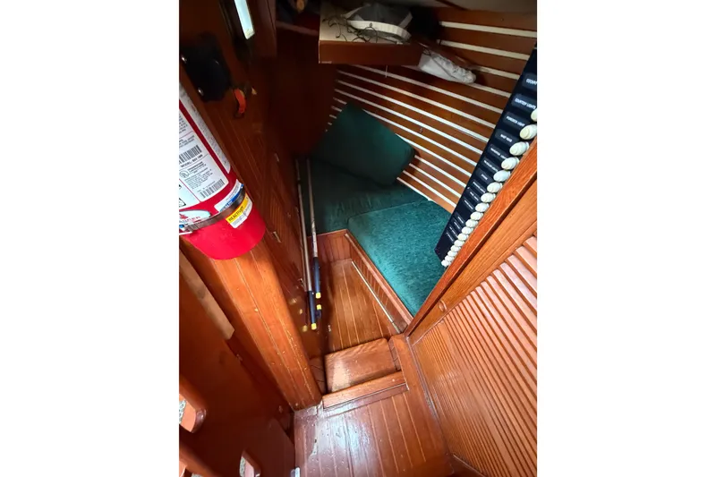 Slide: The Image of 1984 Tayana Aft Cockpit interior with wooden paneling and green cushions. - 11