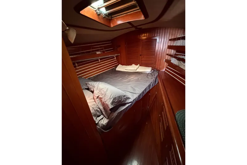 Slide: The Image of Cozy cabin interior of 1984 Tayana Aft Cockpit sailboat with wooden paneling and bed. - 15