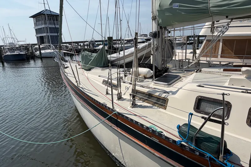 Slide: The Image of 1984 Tayana Aft Cockpit sailboat docked at a marina, showcasing its deck and rigging. - 4