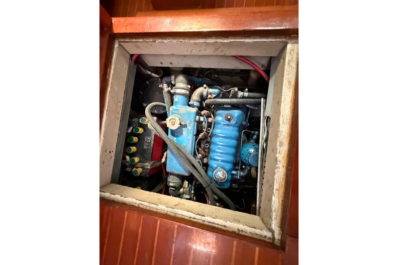 Slide: The Image of Engine compartment of a 1984 Tayana Aft Cockpit sailboat, featuring a blue engine. - 19
