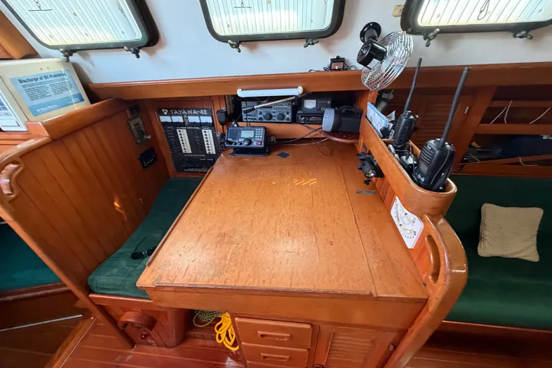 Slide: The Image of Navigation station on 1984 Tayana Aft Cockpit sailboat with communication equipment and wooden interior. - 13