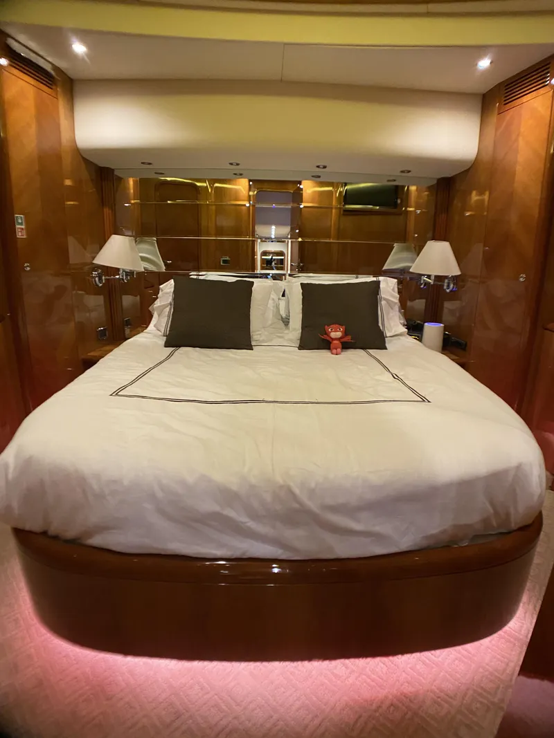 Slide: The Image of Luxurious bedroom interior of a 1999 Azimut 85 Ultimate yacht with elegant wood paneling. - 44