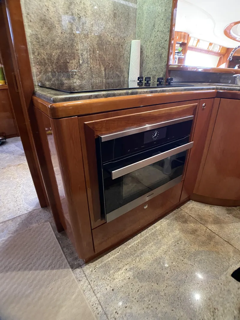 Slide: The Image of 1999 Azimut 85 Ultimate yacht kitchen with modern oven and sleek wood cabinetry. - 27