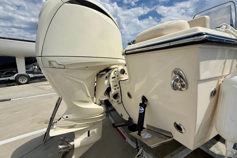 Slide: The Image of 2026 Grady-White Fisherman 180 boat with powerful outboard motor, docked under a cloudy sky. - 29