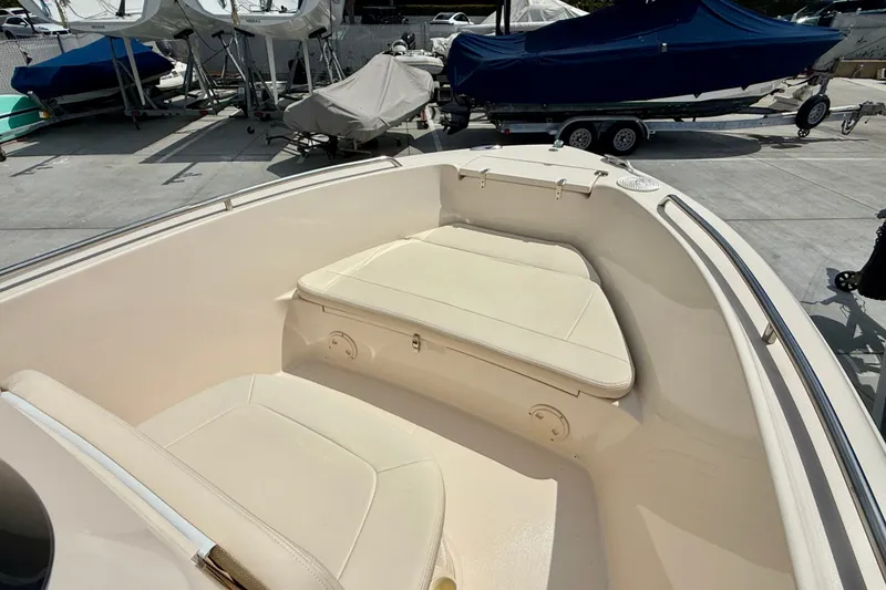 Slide: The Image of 2026 Grady-White Fisherman 180 boat interior with cushioned seating in a marina setting. - 8