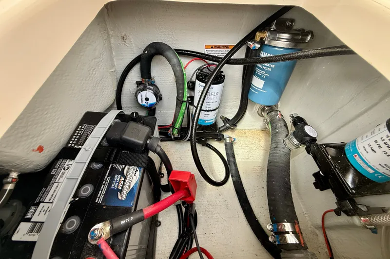 Slide: The Image of Electrical and plumbing components inside a 2026 Grady-White Fisherman 180 boat. - 14