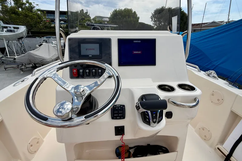 Slide: The Image of 2026 Grady-White Fisherman 180 boat console with steering wheel and navigation screens. - 18