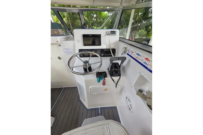 Slide: The Image of 2006 Twin Vee 26 Express boat cockpit with steering wheel and control panel. - 32