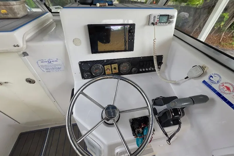 Slide: The Image of 2006 Twin Vee 26 Express boat helm with steering wheel, gauges, and navigation equipment. - 33
