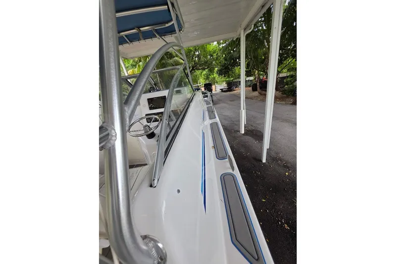 Slide: The Image of 2006 Twin Vee 26 Express boat, side view under canopy, showcasing sleek design. - 41