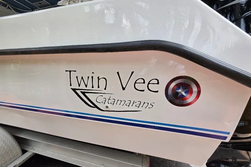 Slide: The Image of 2006 Twin Vee 26 Express catamaran with logo and decorative stripes on the hull. - 13