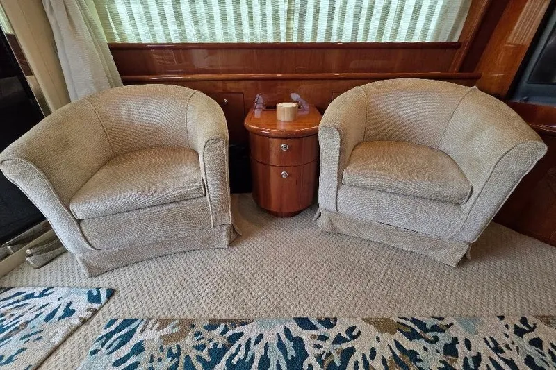 Slide: The Image of Luxurious Neptunus Flybridge MY 2008 interior with two beige armchairs and a wooden side table. - 81