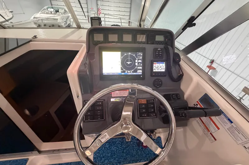 Slide: The Image of 2008 Pursuit OS 285 Offshore boat dashboard with steering wheel and navigation controls. - 17