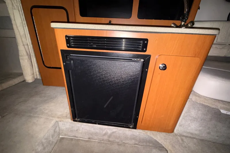 Slide: The Image of 2005 Crownline 270 CR cabin interior with compact kitchenette and storage. - 40