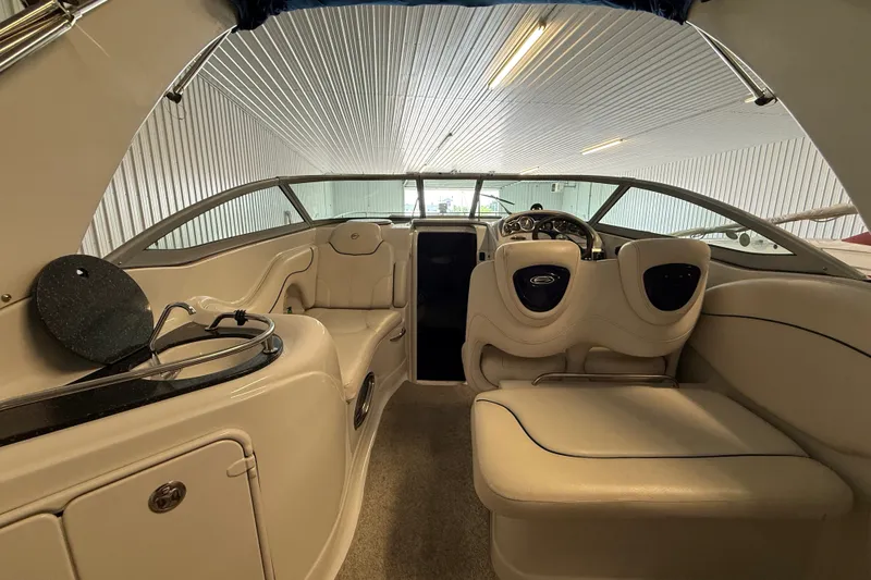 Slide: The Image of Interior of a 2005 Crownline 270 CR boat with beige seating and steering area. - 16